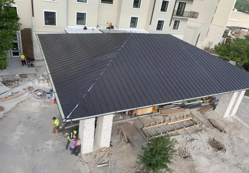 Metal roofing installation team working on a commercial building in Stratmoor